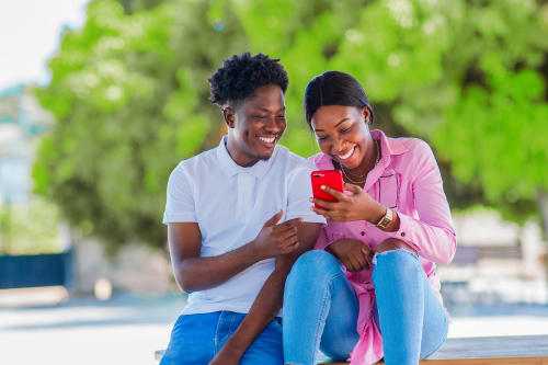 XENO Man and woman smiling while looking at phone